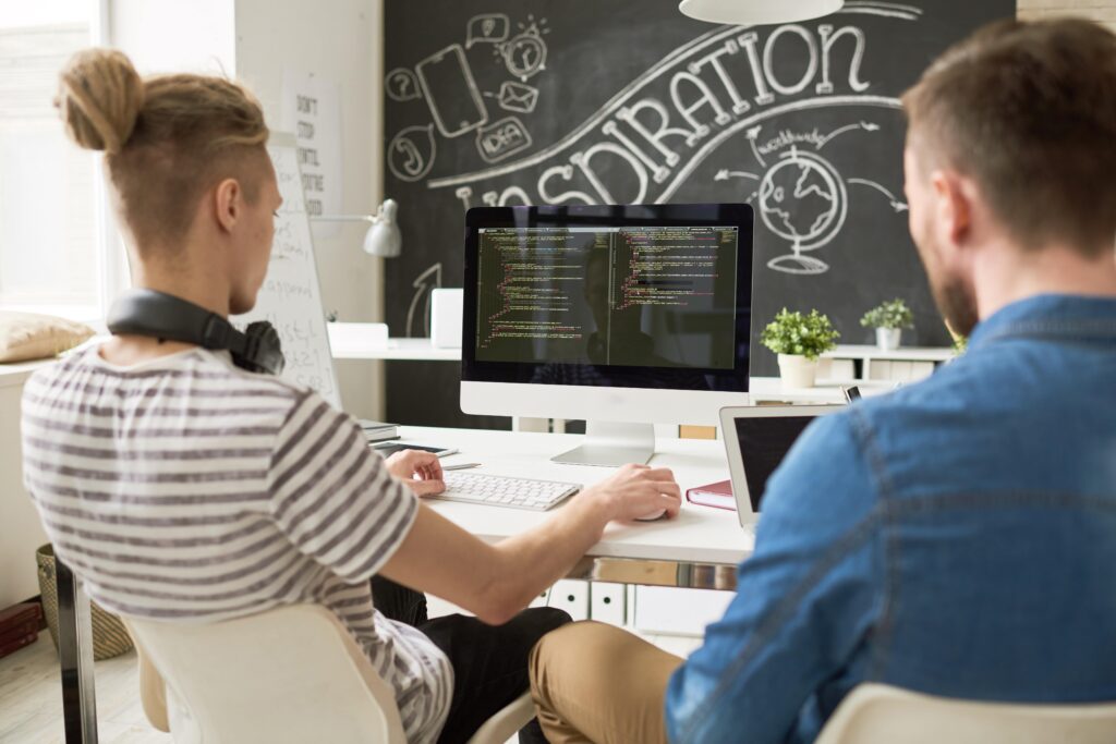 Cover image of the content Key Metrics for a Platform Engineering Team, where there are two men facing a computer with a code.