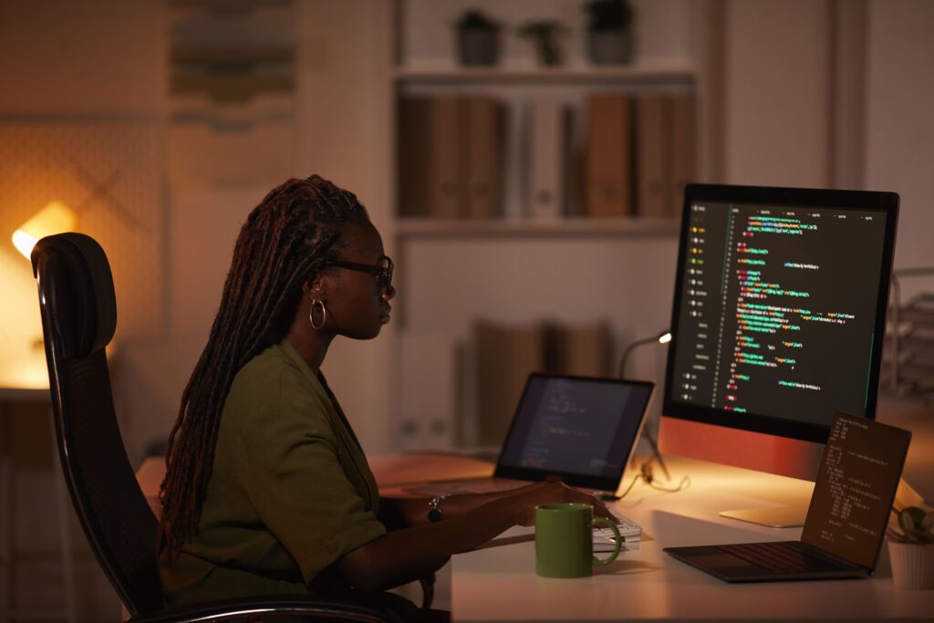 cover image of the content about "faster time-to-market", where there is a woman facing a computer with codes on the screen.