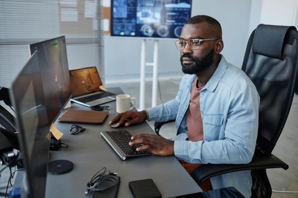 Cover image of the content about "strategic advice for Directors of Engineering", where a man is sitting facing two monitors.