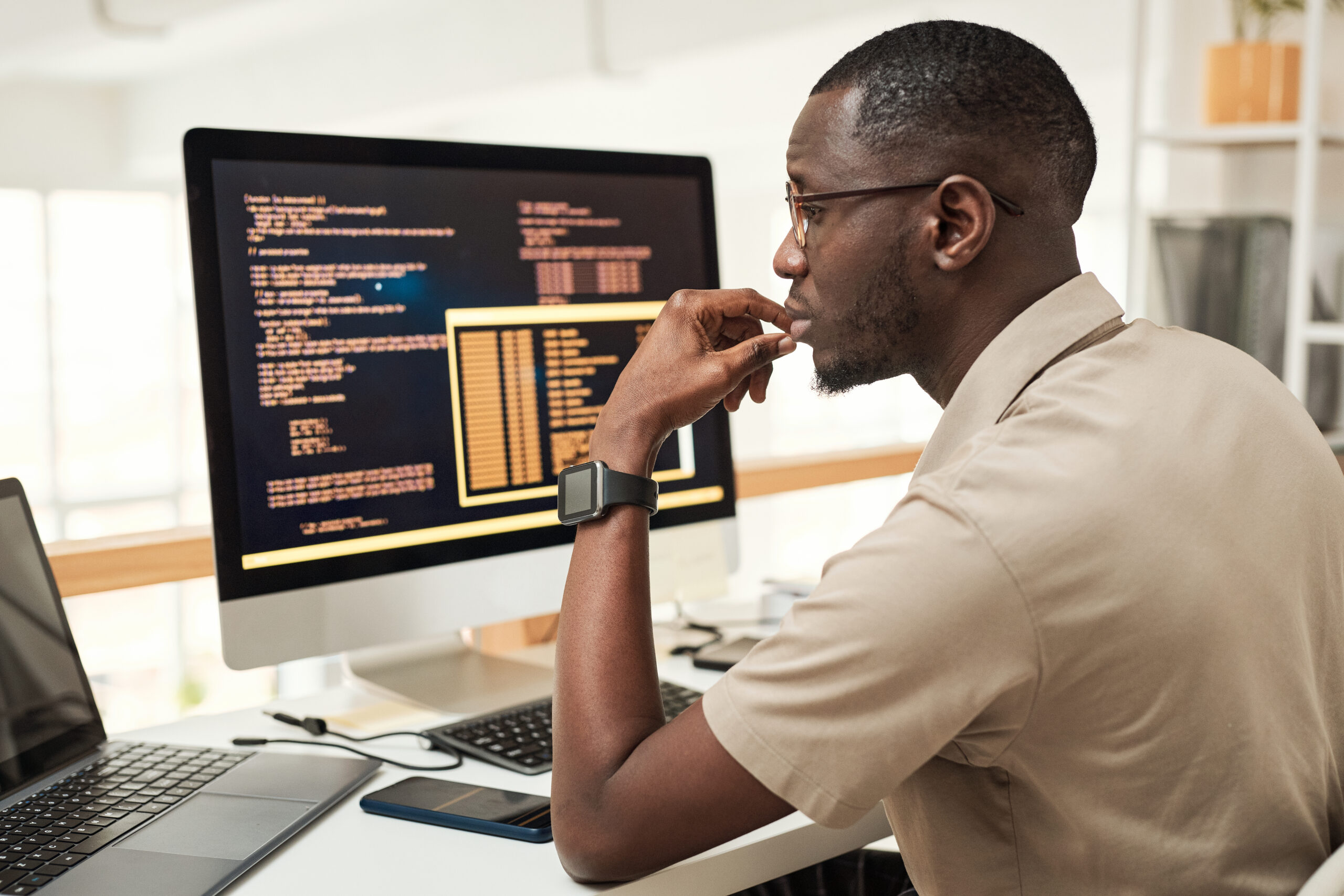 Cover image for the content on 'Freedom and control in using Internal Developer Platforms,' featuring a man in front of a computer screen filled with code.