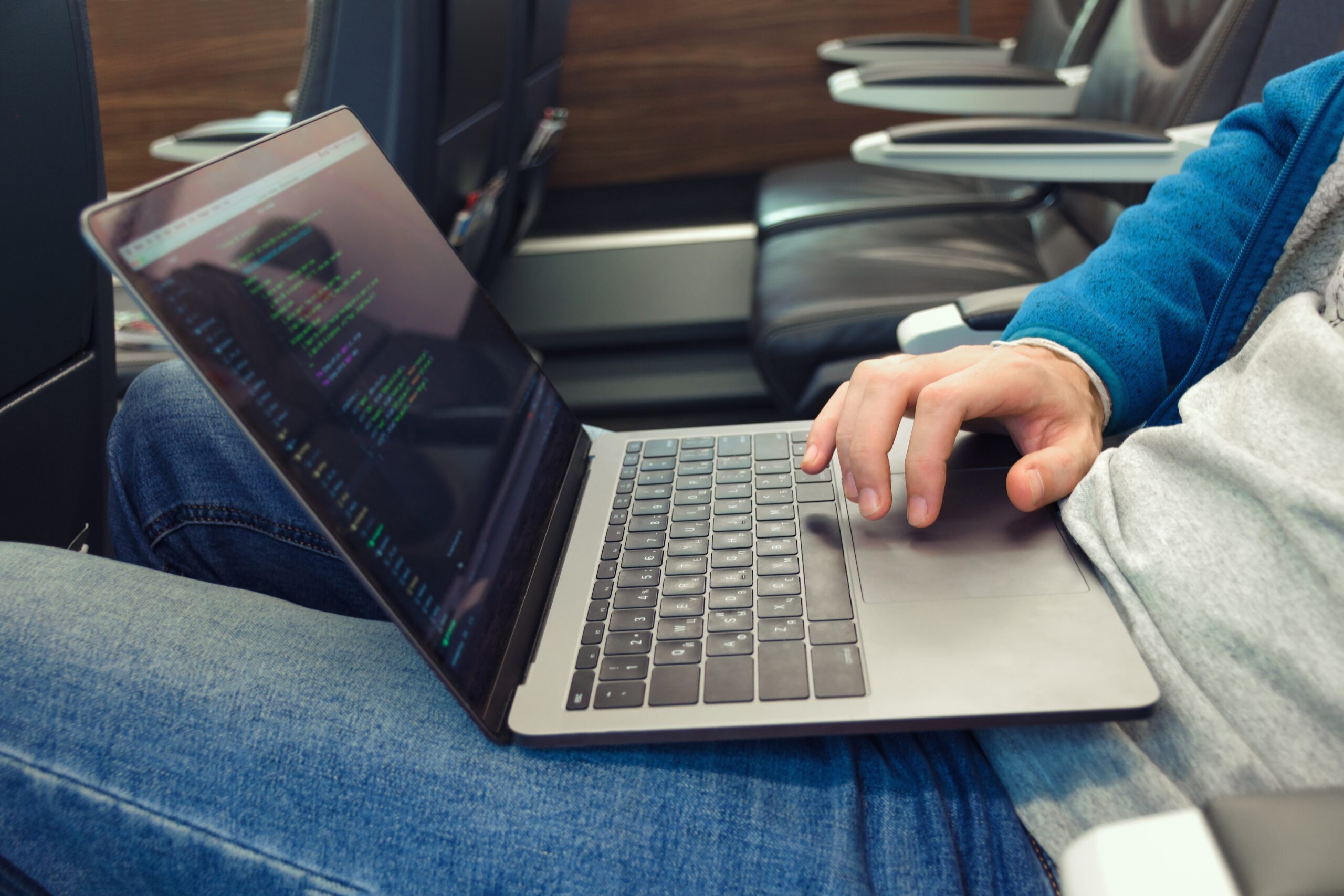 Cover image for the content on 'Analyzing Successful Legacy System Modernization Efforts by Platform Engineers,' featuring a person writing software code on a laptop while in transit.