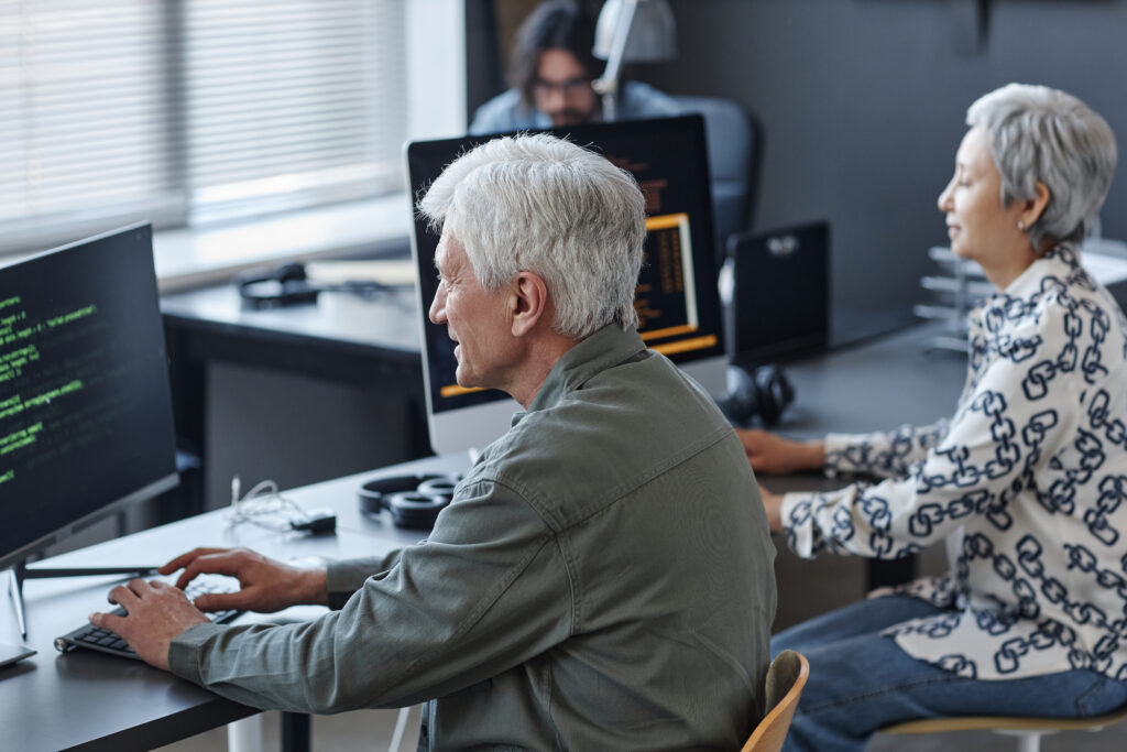 Cover image of the content on Enterprise Development Platform, featuring a white-haired man using a computer in a coding class for seniors.
