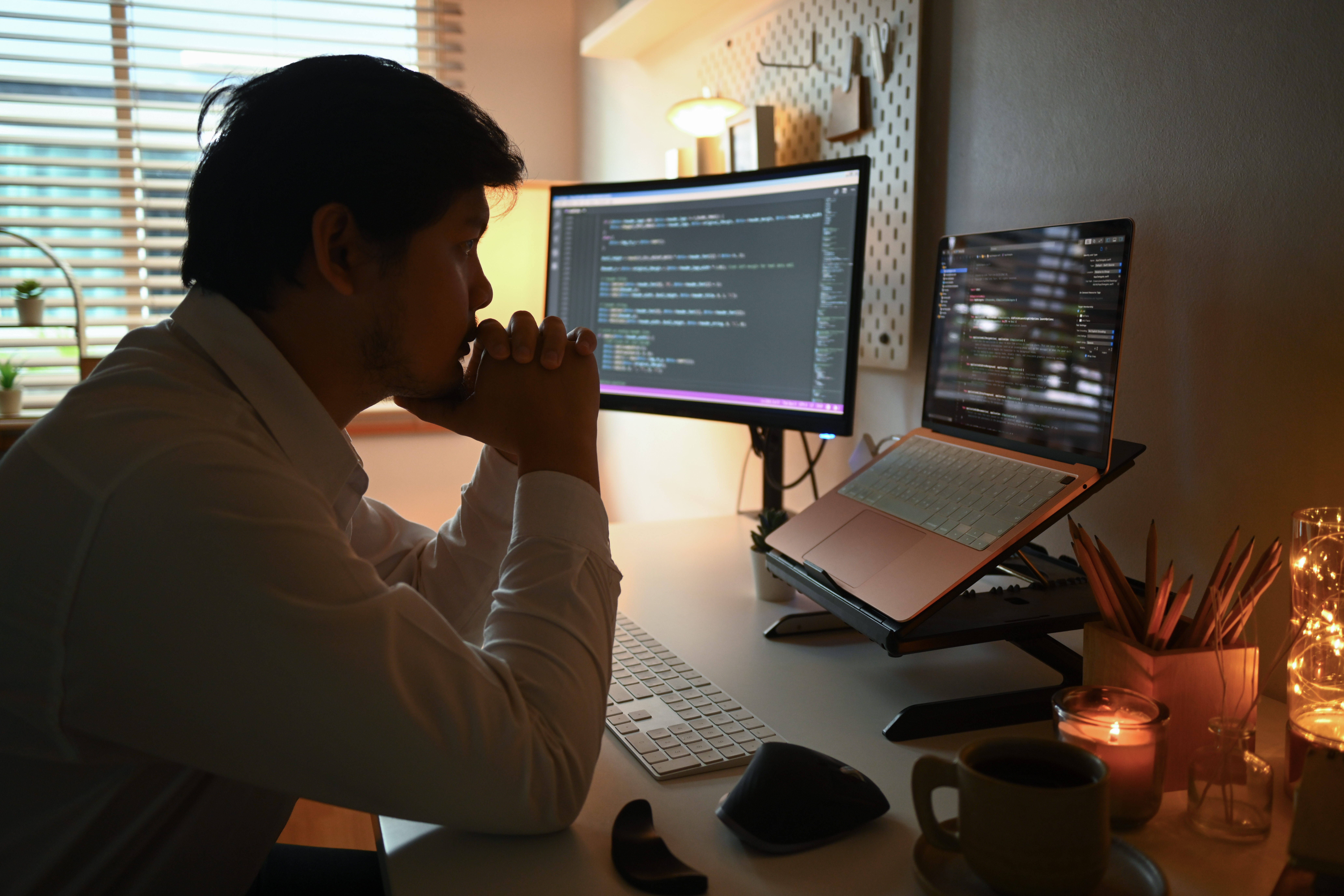 Side view of focused software developer programming on desktop computer.