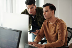 Cover image for the content about acceptance testing. In the image, there are two developers facing a computer discussing codes.
