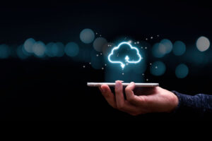 Cover image of the StackSpot Cloud Services content. Where there is a businessman holding a mobile phone with virtual cloud computing to transfer data information and upload download application. Technology transformation concept.