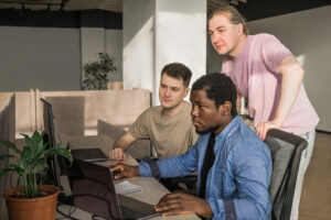 Cover image for the content on SRE Practices. In the content, there are three developers in a room facing the computer.